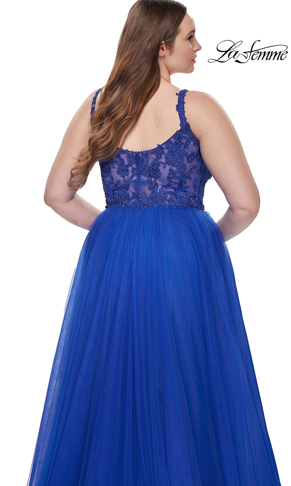 A woman is shown from the back wearing the La Femme Long Prom Dress 31394, a royal blue ball gown with an embroidered lace bodice and tulle skirt. The La Femme logo appears in the top right corner.